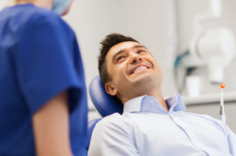 Middle-aged male patient smiling in the dental chair