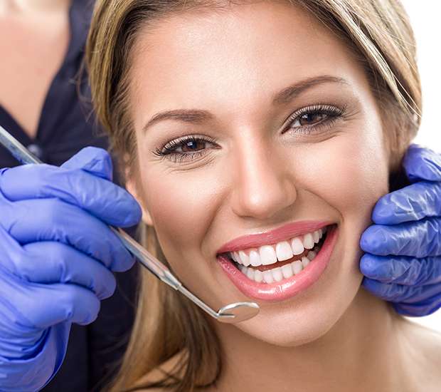 Young woman smiling as her teeth are examined